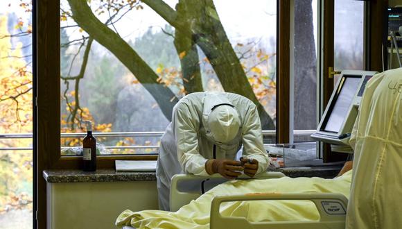 Personal médico descansa junto a un paciente infectado de coronavirus en la unidad de cuidados intensivos del Hospital Lozenets en Sofía el 9 de noviembre de 2021. (Nikolay DOYCHINOV / AFP).