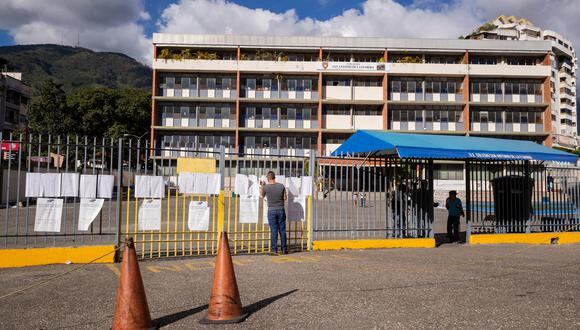 Personas revisan su puesto de votación frente a un centro electoral con poca gente durante el referéndum consultivo por el Esequibo Caracas, Venezuela. (EFE/ RAYNER PEÑA R.).