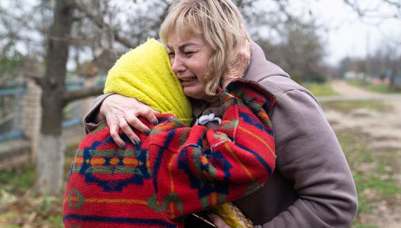 Svitlana Striletska (derecha) abraza a Galina Timofievna (izquierda), de 84 años, en la aldea liberada de Pravdyne, región de Kherson, el 12 de noviembre de 2022, en medio de la invasión rusa de Ucrania. (STRINGER / AFP).