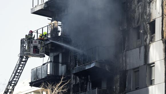 Los bomberos refrescan el bloque residencial de varias plantas devastado ayer por un enorme incendio que mató al menos a cuatro personas, en Valencia el 23 de febrero de 2024. (Foto de JOSÉ JORDANIA / AFP)