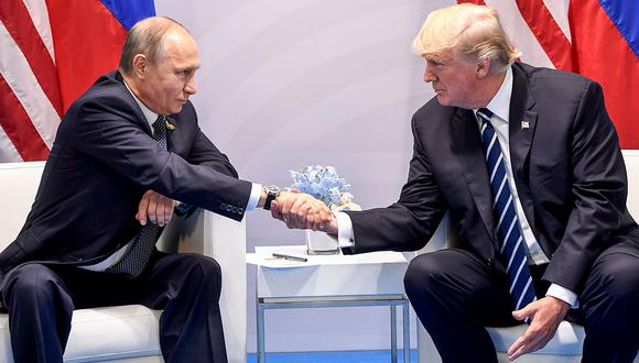 TOPSHOT - US President Donald Trump and Russia's President Vladimir Putin shake hands during a meeting on the sidelines of the G20 Summit in Hamburg, Germany, on July 7, 2017. / AFP / SAUL LOEB