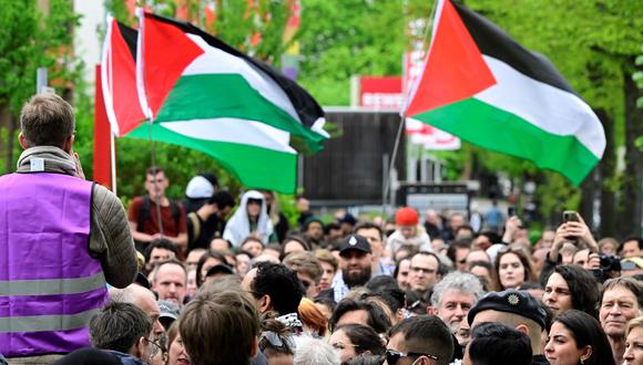La gente ondea banderas palestinas mientras espera frente a la sede de la llamada Conferencia Palestina el 12 de abril de 2024 en Berlín. (Foto de JOHN MACDOUGALL / AFP)