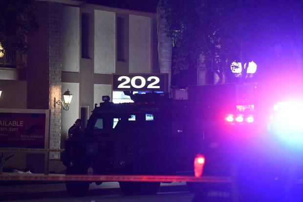 La policía monta guardia en las afueras de un edificio de oficinas donde 4 personas murieron en un tiroteo en Orange, California, el 31 de marzo de 2021. (Patrick T.FALLON / AFP).