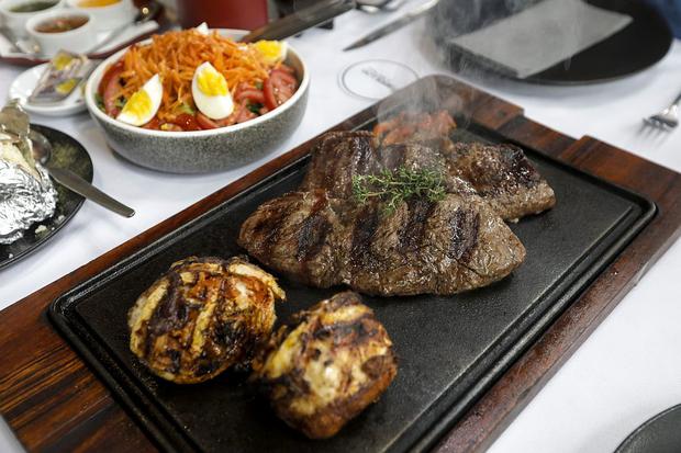 Uruguayan short steak, Angus cut lengthwise.  This is 800 grams of meat.  A chicken pamplona, ​​a Uruguayan grill style made of breast with ham, cheese, bell pepper, bacon strips, chimichurri, wrapped in lamb belly fabric.