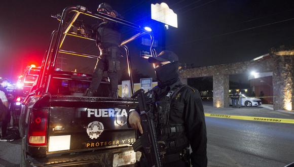 Integrantes de la policía resguardan el exterior de un motel en cuyo interior se localizó el cuerpo sin vida de una mujer, en el municipio de Escobedo, estado de Nuevo León, México. (EFE/Gabriela López).