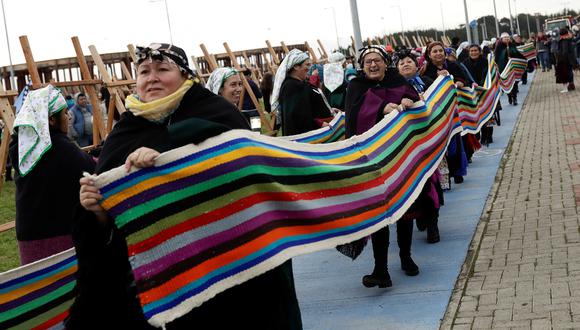 Mujeres indígenas mapuche cargan sus telares mientras buscan romper un récord mundial al reunir tejidos de telar que en conjunto medirán más de 1 kilómetro de largo en Puerto Saavedra, Chile.