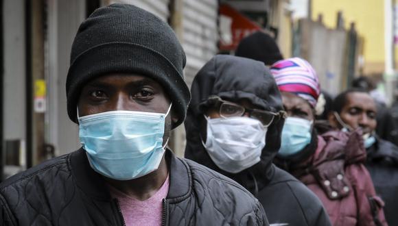 Coronavirus en New York | La gente espera una distribución de máscaras y alimentos del reverendo Al Sharpton en el barrio de Harlem, en Nueva York. (Foto AP / Bebeto Matthews).