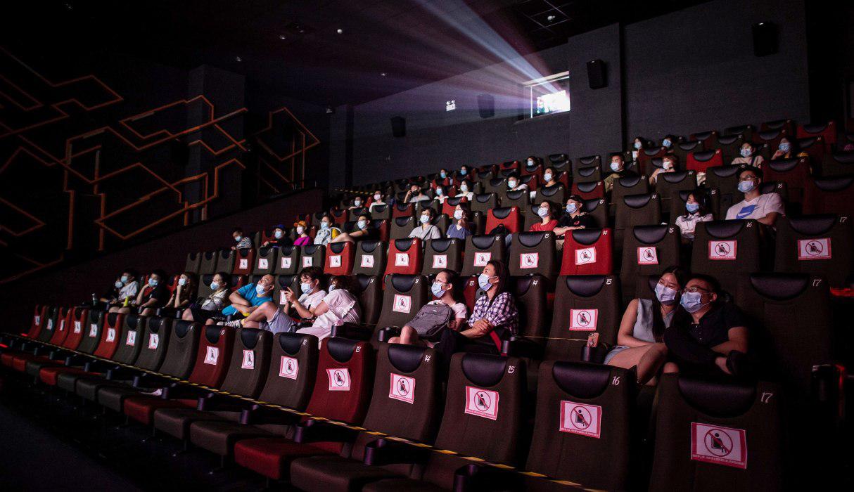 Personas miran una película mientras se sientan separadas por el coronavirus en el primer día de la reapertura de los cines en Wuhan, provincia central de Hubei de China. (AFP / STR).