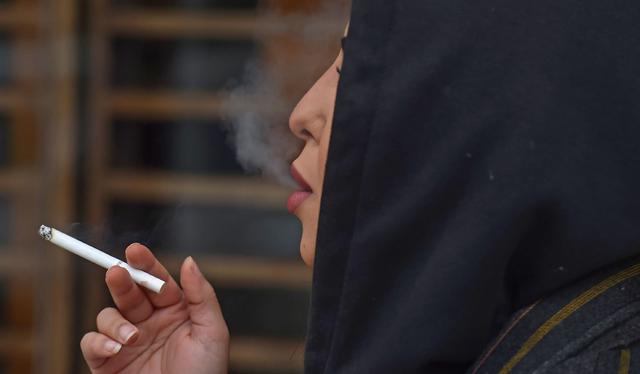 Najla, una mujer saudita de 26 años, fuma públicamente en una cafetería en el centro de Riad. (Foto de FAYEZ NURELDINE / AFP).