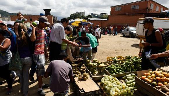 La gente compra comestibles en el mercado municipal de Coche, un barrio de Caracas. (Foto: AFP)