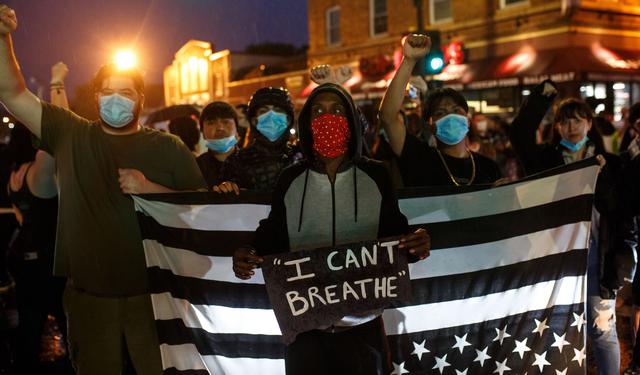 La gente levanta los puños durante una protesta cerca del lugar donde murió George Floyd mientras estaba bajo custodia de la Policía de Minneapolis, Estados Unidos. (Foto por Kerem Yucel / AFP).