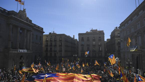 Las personas que portan banderas independentistas catalanas de Estelada se reúnen en la Plaza Sant Jaume de Barcelona el 1 de octubre de 2022. (Foto: Josep LAGO / AFP)