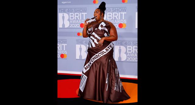 Con un vestido similar a un sobre de chocolate, la cantante Lizzo se presentó a la gala. Este modelo vanguardista es de la marca Moschino. (Foto: AFP)