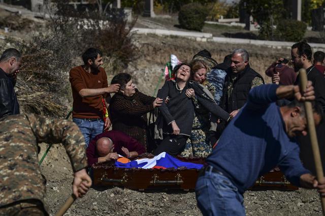Una madre llora sobre el ataúd con el cuerpo de su  hijo en Stepanakert durante los combates por la región separatista de Nagorno-Karabaj el 17 de octubre de 2020. (Foto: ARIS MESSINIS / AFP)