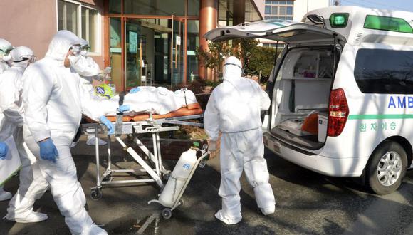 Los trabajadores médicos llevan a un paciente sospechoso de contraer el nuevo coronavirus hacia una ambulancia en el Hospital Daenam en Cheongdo, Corea del Sur. (Foto: AP).