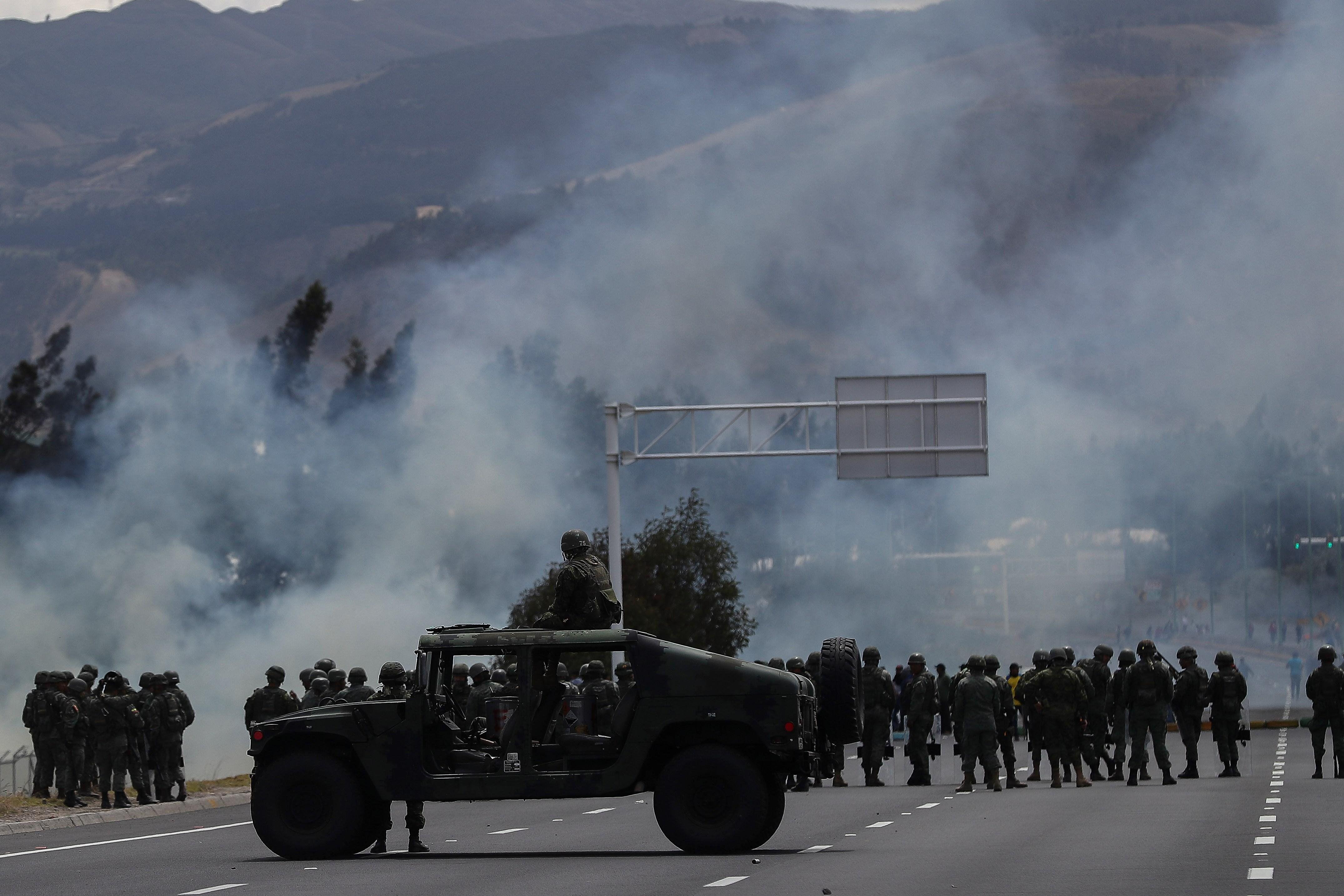 Militares montan guardia mientras indígenas protestan contra las medidas del presidente Lenín Moreno en las afueras de la ciudad de Latacunga, al sur de Quito. (EFE/José Jácome).