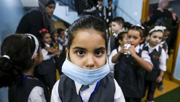 Una niña que usa una máscara facial posa para una foto durante una sesión de concientización sobre el coronavirus COVID-19 celebrada en un jardín de infantes en Gaza el 10 de agosto de 2020. (Foto: Mohammed ABED / AFP).