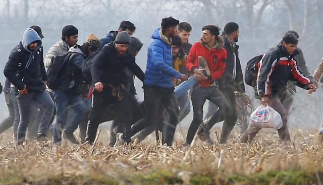 Los migrantes llevan a un hombre herido cerca del cruce fronterizo de Pazarkule en Turquía con Kastanies en Grecia, después de que la policía de Grecia lanzó gases lacrimógenos contra ellos. (Reuters).