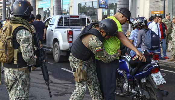 Un miembro del ejército cachea a un hombre en motocicleta en Guayaquil, Ecuador, el 3 de abril de 2023, luego de que se declarara el estado de emergencia en áreas del país que se tambaleaban por la lucha contra el crimen relacionado con las drogas. (Foto de Gerardo MENOSCAL / AFP)