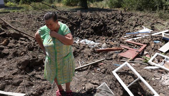 Una mujer reacciona junto a un cráter causado por los bombardeos rusos en la ciudad de Toretsk, en la región de Donetsk, el 17 de julio de 2022. (Foto de Anatolii Stepanov / AFP)