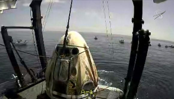 En esta captura de video de la NASA se aprecia al Crew Dragon Endeavor poco después de ser izada en el Golfo de México. Los astronautas que viajaban en la nave, Behnken y Hurley, regresaron a la tierra después de pasar 64 días en el espacio. (NASA / AFP)