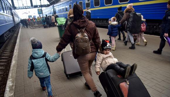 Una mujer con niños camina en la estación de tren mientras huyen de la invasión rusa de Ucrania, en Lviv, Ucrania. (Fotoreferencial: REUTERS/Pavlo Palamarchuk).