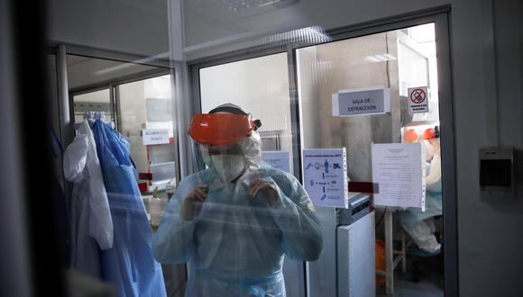 Un trabajador del Instituto de Ciencias Biomédicas (ICBM) de la Facultad de Medicina de la Universidad de Chile se alista para procesar pruebas de detección de coronavirus. (EFE/Alberto Valdés).
