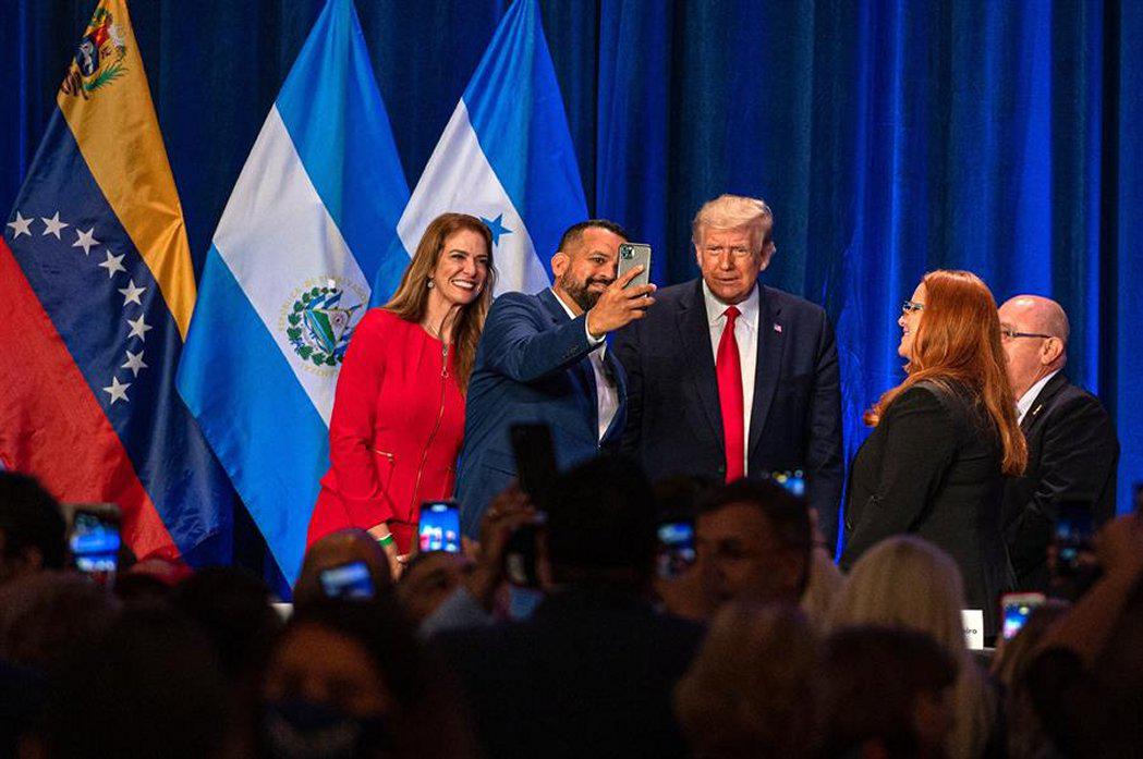 La experta en bienes raíces, Karla Salvatierra (i), y el banquero puertorriqueño Hiram Turul, se toman una fotografía con el presidente de los Estados Unidos, Donald J. Trump, frente a la cubana Carolina Ferreiro, de Pharma Natural, y el presidente de Americas Community Cinter, el colombiano Fabio Andrade, durante el encuentro de "Latinos por Trump" el viernes 25 en el complejo hotelero Trump National Doral Miami, sin distanciamiento ni mascarillas. (Foto: EFE/Giorgio Viera)