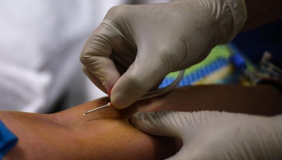 Imagen referencial. Una enfermera (derecha) inserta una aguja en el brazo de un paciente que se ha recuperado del coronavirus, el 22 de abril de 2020. (Maria TAN / AFP).