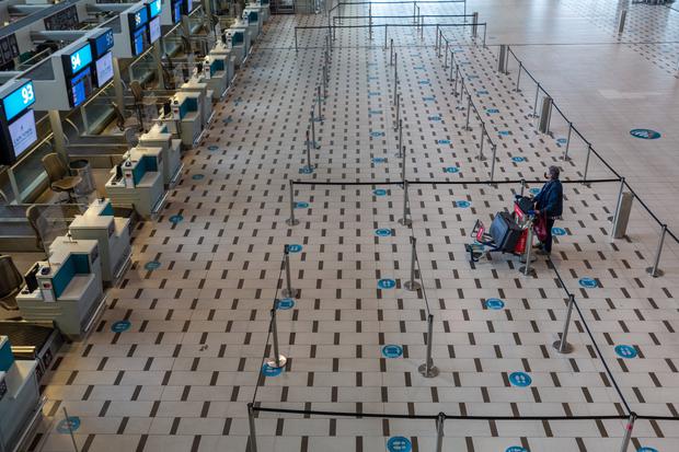 A passenger looks at check-in locations at the airport in Cape Town, South Africa, a country hit by the ban on international flights.  (Bloomberg).