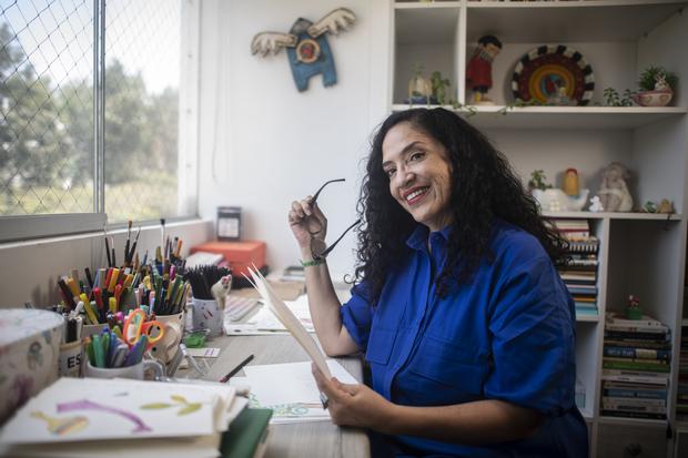 Wendy at her workstation surrounded by pencils, markers and watercolors.  (Photo: Elias Alfajme).