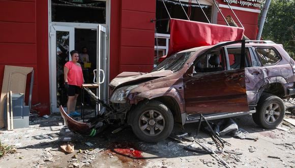 Un residente local se encuentra junto a un automóvil dañado en el lugar de un ataque con misiles en Chernihiv, el 19 de agosto de 2023. (Foto de Anatolii STEPANOV / AFP)