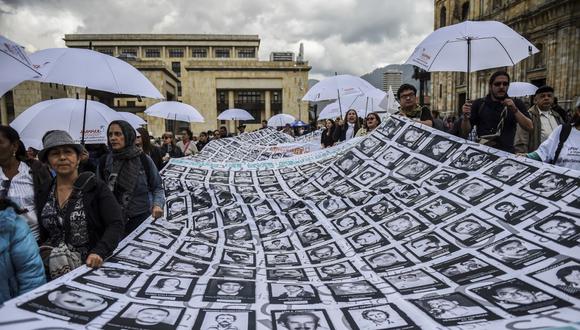 Imágenes de personas desaparecidas y víctimas del conflicto armado se muestran durante una protesta frente al teatro Colón en Bogotá en noviembre del 2017. (Foto referencial / Raúl Arboleda / AFP)