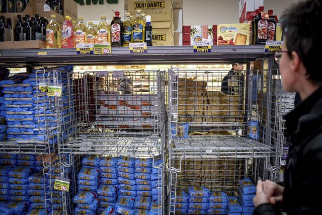 Un hombre mira estantes vacíos en un supermercado en Milán, Italia. (Foto: AP)