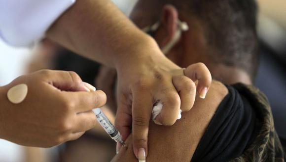 Un indigente es inoculado con la vacuna CoronaVac contra el COVID-19 durante una campaña de vacunación para personas en las calles de Sao Paulo, Brasil, el 30 de marzo de 2021. (Miguel SCHINCARIOL / AFP).