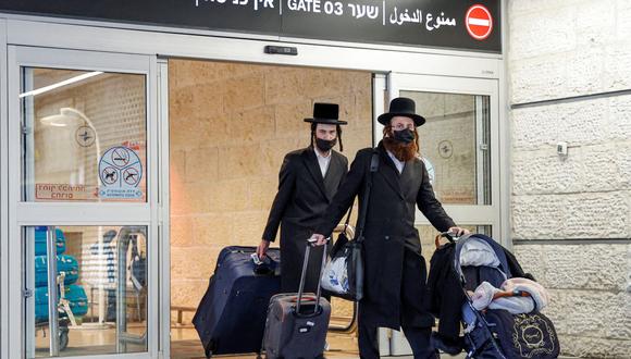 Los pasajeros que llegan desde Kiev caminan con su equipaje en el aeropuerto Ben Gurion de Israel en Lod, cerca de Tel Aviv, el 13 de febrero de 2022. (JACK GUEZ / AFP).