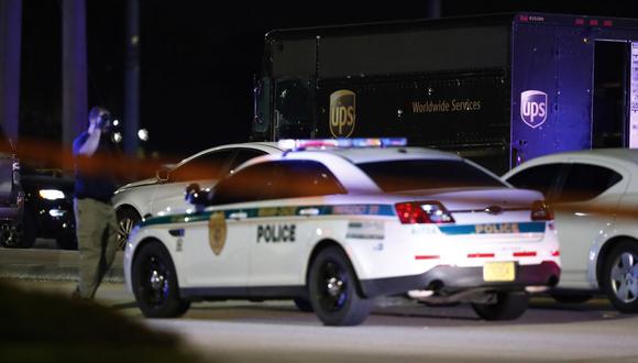 Las autoridades caminaron cerca de un camión de UPS y otros vehículos en el lugar del tiroteo en Miramar, Florida. Cuatro personas, incluido un conductor de UPS, murieron el jueves después de que los ladrones robaron el camión del conductor y condujeron a la policía una persecución que terminó en disparos en una concurrida intersección de Florida durante la hora pico, dijo el FBI. (AP)