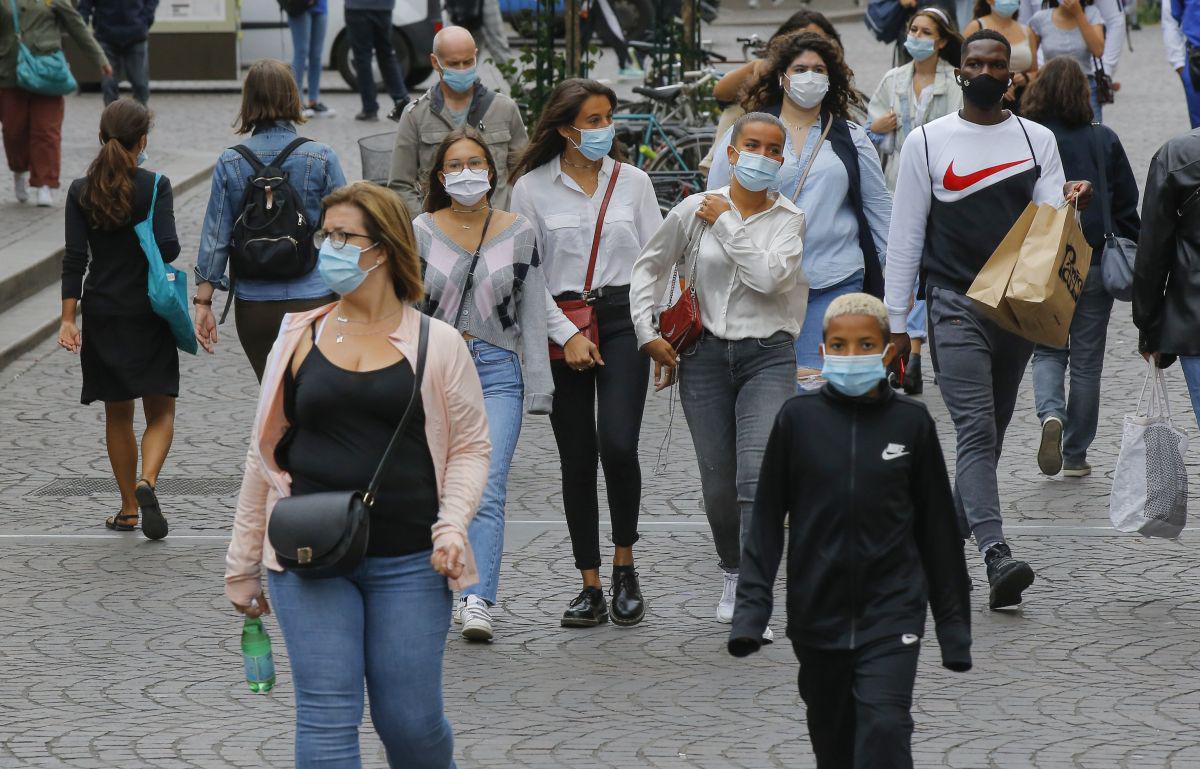 Un grupo de ciudadanos camina en un área comercial con mascarillas como precaución contra el coronavirus en París, Francia. (Foto: AP)