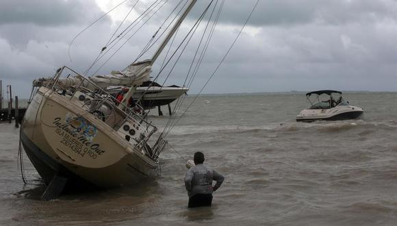 Un hombre observa una embarcación encallada en una playa debido a los fuertes vientos de la tormenta tropical Gamma en Cancún, estado de Quintana Roo (México). (EFE/Alonso Cupul).