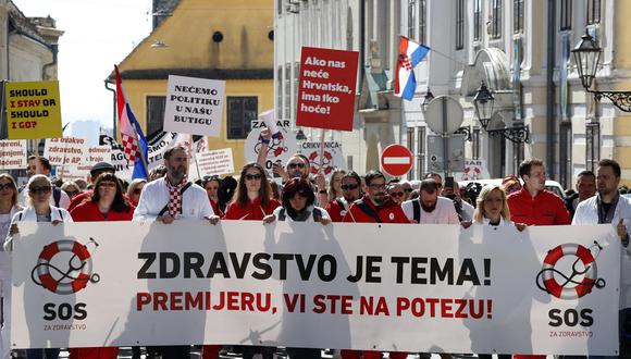 Los manifestantes participan en una manifestación de médicos y trabajadores médicos por las condiciones laborales y organizativas en el sistema de salud de Croacia, en la Plaza de San Marcos en Zagreb, el 18 de marzo de 2023. (Foto de Denis LOVROVIC / AFP)
