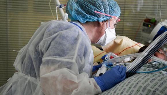 Una trabajadora sanitaria atiende a un paciente en la unidad de cuidados intensivos para infectados de coronavirus en el hospital AP-HP Ambroise Pare en Boulogne-Billancourt, cerca de París, el 8 de marzo de 2021. (Foto de ALAIN JOCARD / AFP).