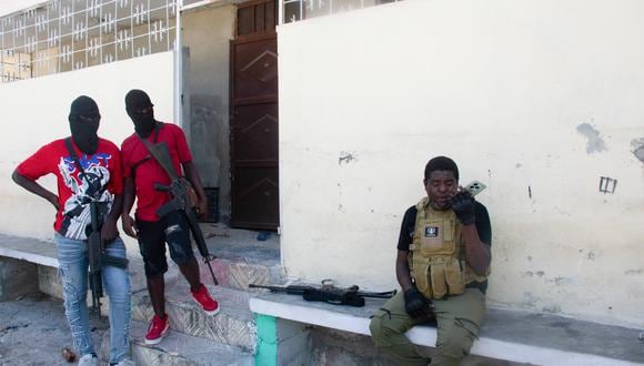 El líder de la pandilla Jimmy 'Barbecue' Cherizier habla por teléfono antes de una misión, mientras dos de sus hombres observan, en Puerto Príncipe, Haití, el 5 de marzo de 2024. (Clarens SIFFROY / AFP).