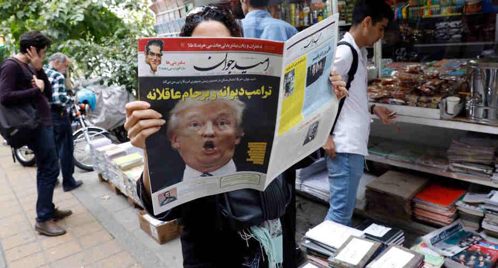 Una mujer iraní lee un periódico en donde se tilda de "loco" a Trump el 14 de octubre. (Foto: EFE)