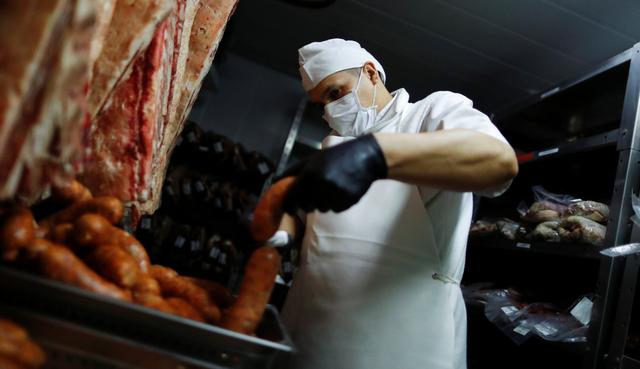 Gustavo, un carnicero que trabaja en la parrilla Don Julio, observa una salchicha en Buenos Aires, Argentina, ciudad afectada por el coronavirus. (REUTERS/Agustin Marcarian).