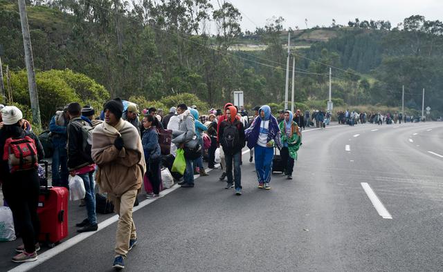 Los venezolanos que se dirigen al Perú caminan por la carretera Panamericana en Tulcán, Ecuador, después de cruzar la frontera  desde Colombia. (AFP).