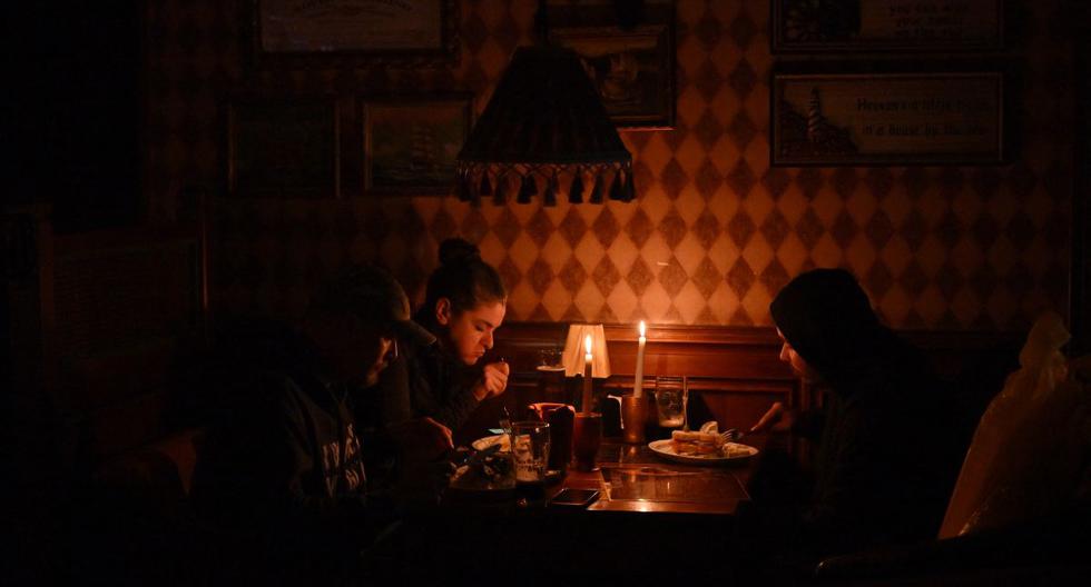 Las personas permanecen en un restaurante a la luz de las velas debido a un corte de energía en Kiev, la capital de Ucrania. (SERGEI SUPINSKY / AFP).