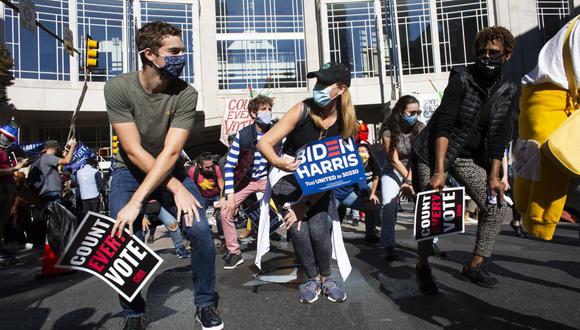 Los simpatizantes de Joe Biden bailan mientras exigen que se cuenten todos los votos frente al Centro de Convenciones de Pensilvania. (Foto de Kena Betancur / AFP).