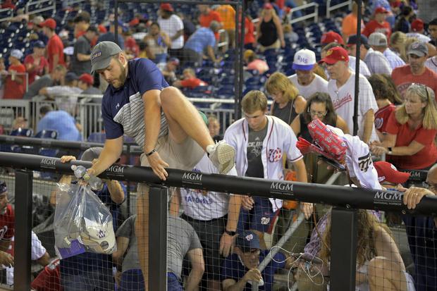Fans took to the field after hearing shots from outside the stadium, during a baseball game between the San Diego Padres and the Washington Nationals at Nationals Park in Washington.