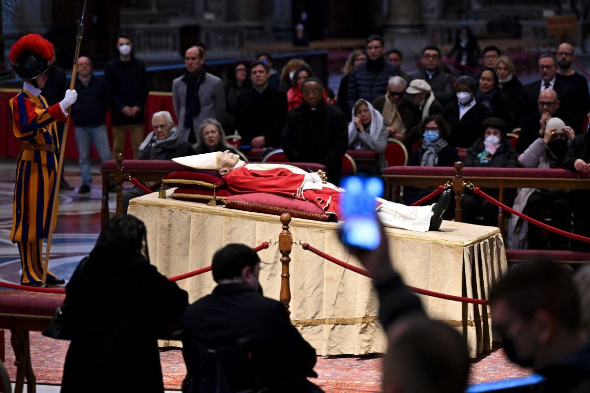 People take pictures of Pope Emeritus Benedict XVI as his body lies in St. Peter's Basilica in the Vatican, on January 2, 2023. (ANDREAS SOLARO / AFP).