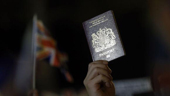 Una persona muestra un pasaporte británico durante una manifestación pidiendo apoyo de Reino Unido, frente al Consulado General Británico de Hong Kong, China, el 23 de octubre de 2019. (EFE/EPA/LYNN BOBO).